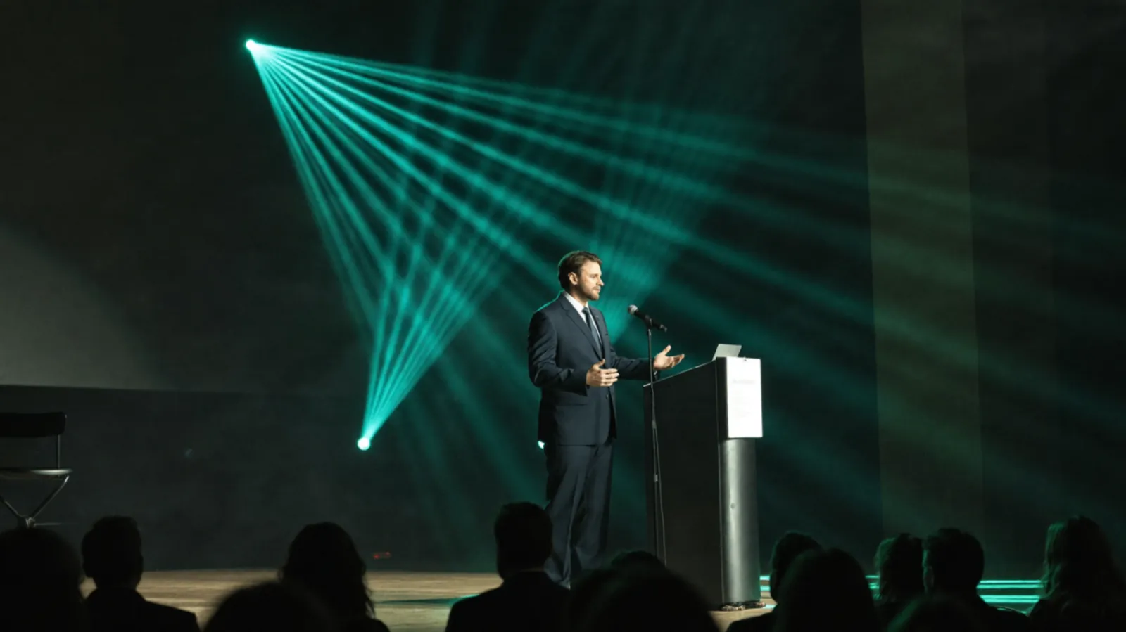 Alessio Vinassa speaking from a stage podium